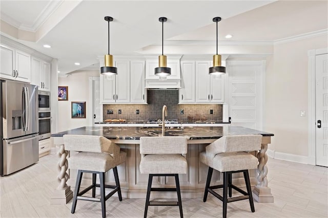 kitchen featuring stainless steel appliances, white cabinetry, and a center island with sink