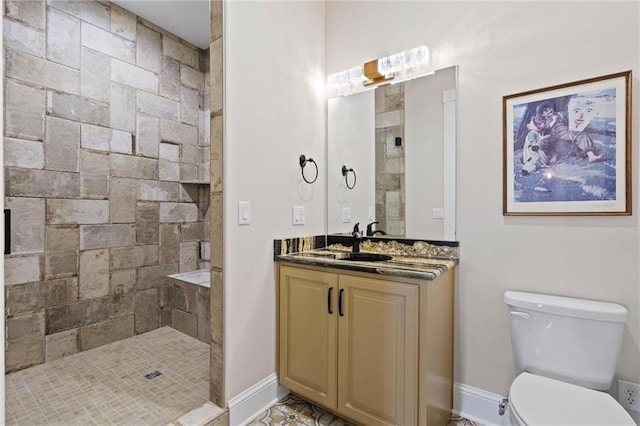 bathroom featuring vanity, toilet, and a tile shower