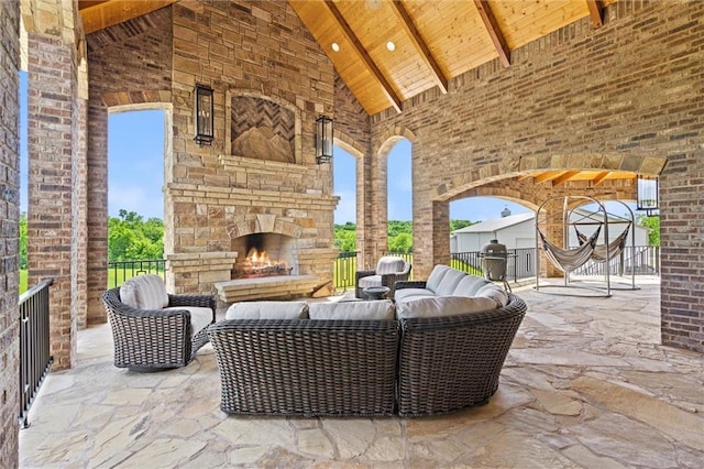 view of patio with an outdoor living space with a fireplace and area for grilling