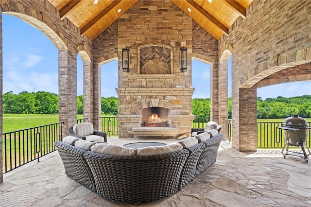 view of patio featuring an outdoor stone fireplace and grilling area