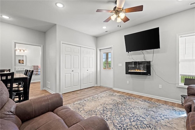 living room featuring light wood-type flooring and ceiling fan