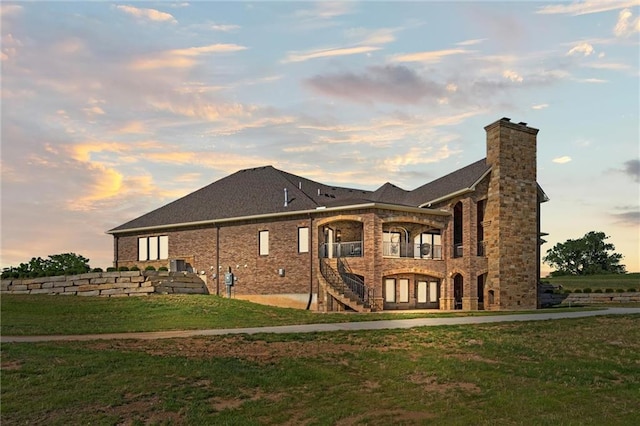 back house at dusk with a lawn