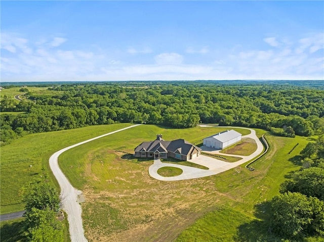 drone / aerial view featuring a wooded view