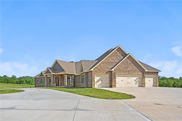 craftsman inspired home featuring a garage, driveway, brick siding, and a front lawn