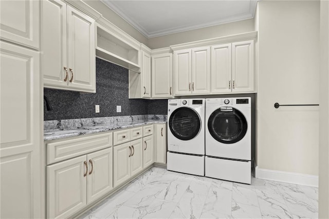 clothes washing area featuring cabinet space, baseboards, ornamental molding, marble finish floor, and washer and dryer