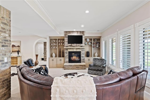 living room featuring a large fireplace, crown molding, and recessed lighting