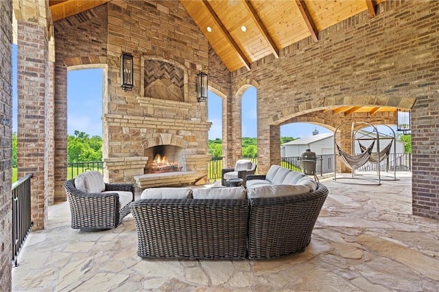 view of patio with an outdoor living space with a fireplace, a grill, and fence