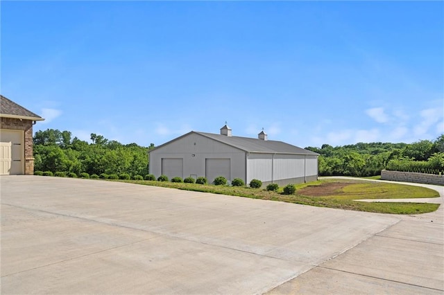 view of property exterior featuring a detached garage and an outdoor structure