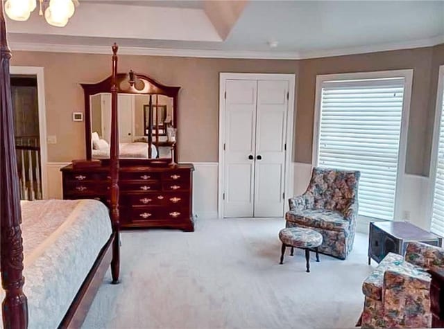 carpeted bedroom with a closet and crown molding