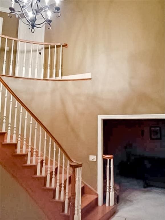 staircase with a chandelier