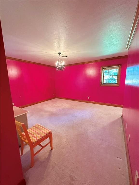 carpeted spare room featuring crown molding and an inviting chandelier