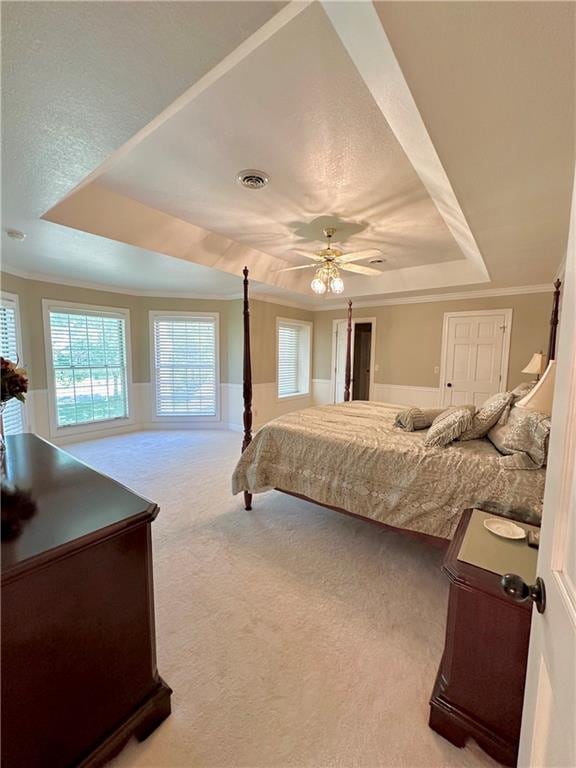 bedroom with carpet, a raised ceiling, ceiling fan, and ornamental molding