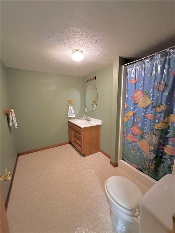 bathroom with tile floors, vanity, toilet, and a textured ceiling