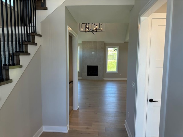 corridor with light hardwood / wood-style flooring and a notable chandelier