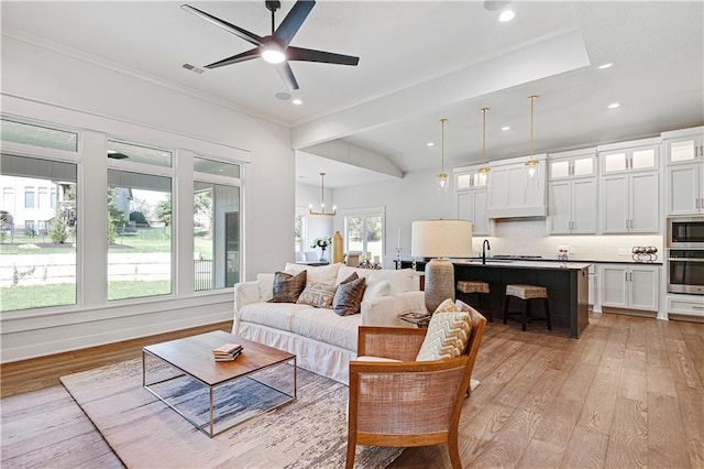 24932 W 98th Pl, Lenexa, KS 66227 - living room featuring light wood-type flooring, ornamental molding, ceiling fan, recessed lighting, and a chandelier