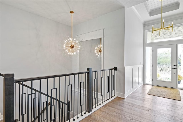 24932 W 98th Pl, Lenexa, KS 66227 - foyer featuring a chandelier, wood finished floors, a decorative wall, wainscoting, and a tray ceiling
