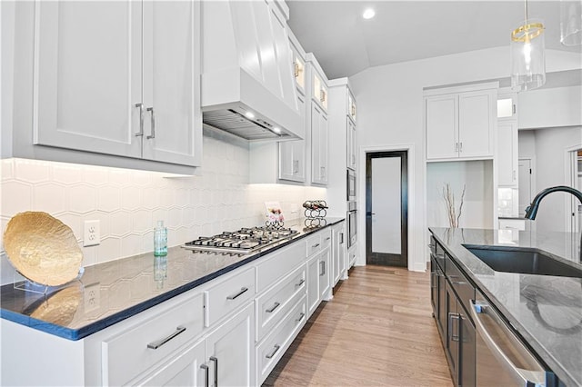 24932 W 98th Pl, Lenexa, KS 66227 - kitchen with stainless steel appliances, a sink, premium range hood, dark stone counters, and white cabinets
