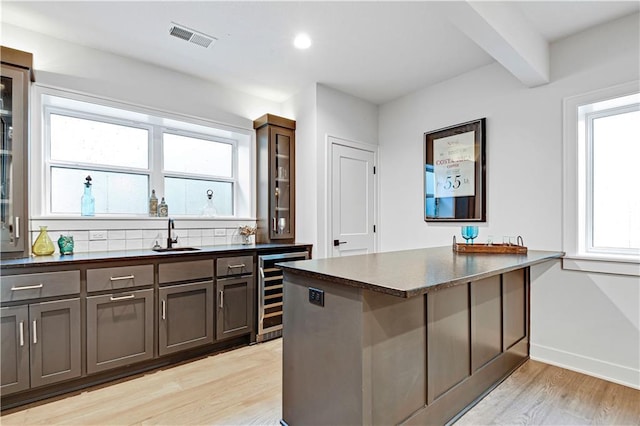 24932 W 98th Pl, Lenexa, KS 66227 - kitchen featuring wine cooler, light wood-style floors, a sink, a peninsula, and recessed lighting