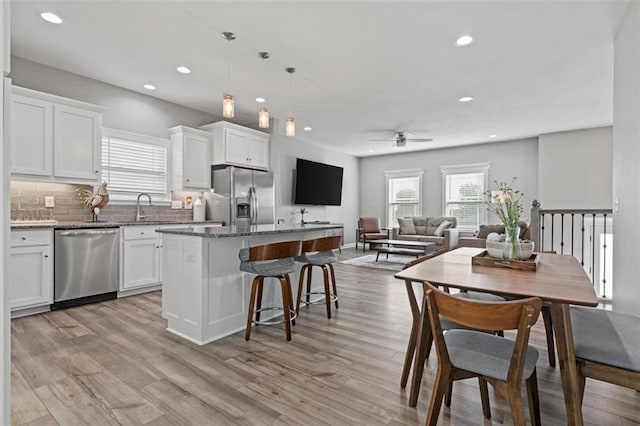 kitchen with white cabinets, appliances with stainless steel finishes, open floor plan, and a center island