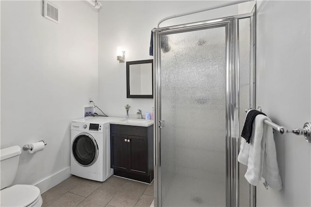 bathroom with tile patterned flooring, vanity, washer / dryer, toilet, and walk in shower