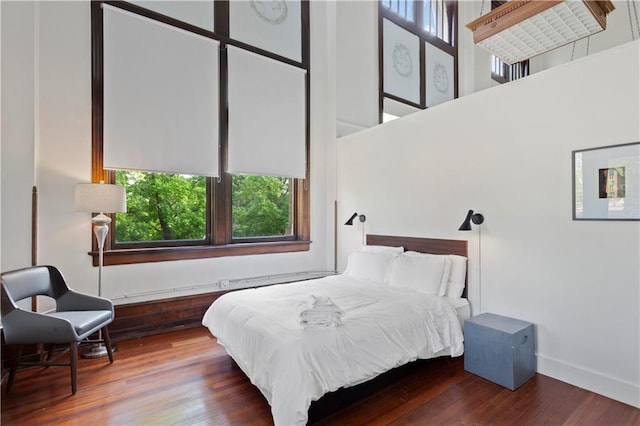 bedroom featuring a high ceiling and hardwood / wood-style floors