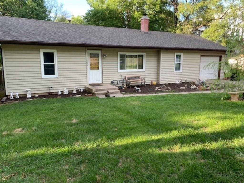 view of front of home featuring a front yard and a garage