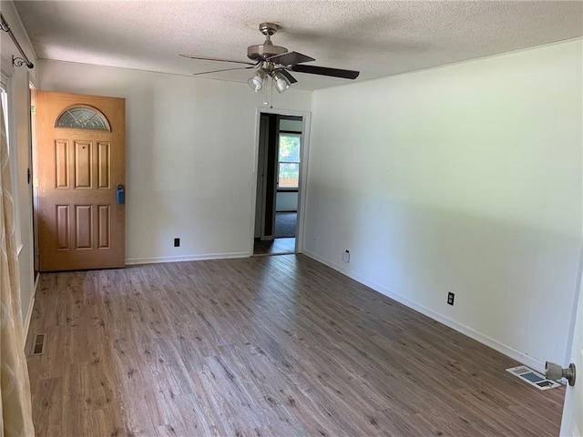 spare room featuring ceiling fan, wood-type flooring, and a textured ceiling