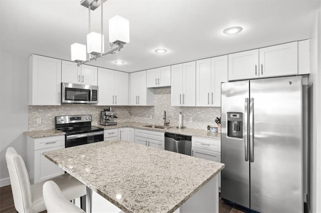 2980 Baltimore Ave Unit 2204, Kansas City, MO 64108 - kitchen with appliances with stainless steel finishes, a sink, white cabinetry, and light stone counters