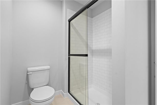 full bath with baseboards, a shower stall, toilet, and tile patterned floors