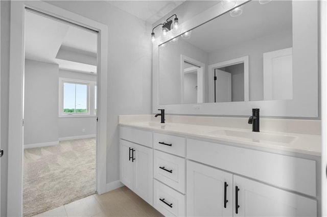 full bathroom with double vanity, tile patterned flooring, baseboards, and a sink