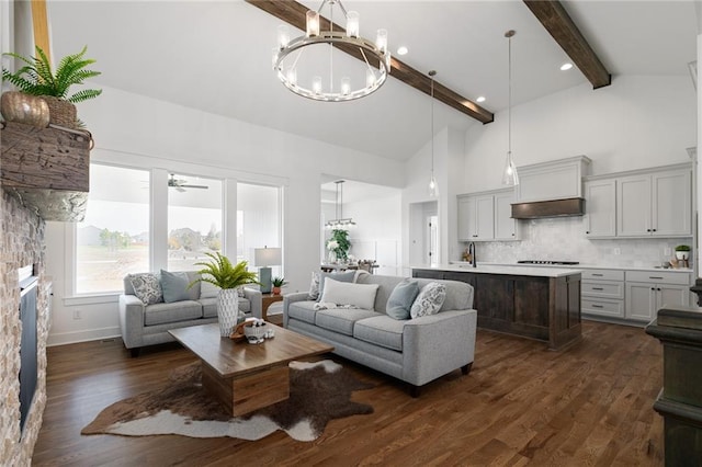 living room featuring a stone fireplace, sink, high vaulted ceiling, beamed ceiling, and dark hardwood / wood-style floors