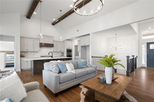 living room with dark hardwood / wood-style floors, high vaulted ceiling, beamed ceiling, and a chandelier