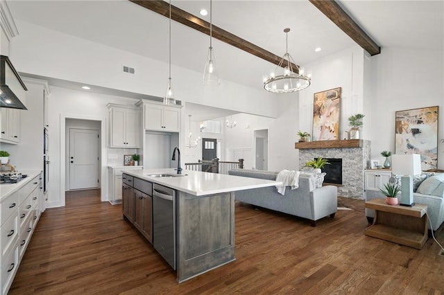 kitchen featuring white cabinetry, a kitchen island with sink, decorative light fixtures, sink, and high vaulted ceiling