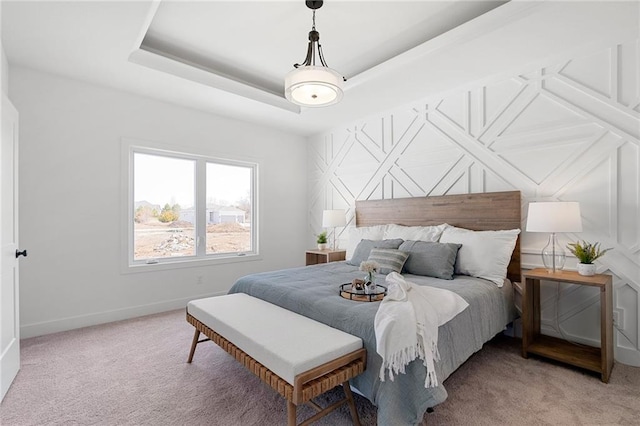 carpeted bedroom with a tray ceiling