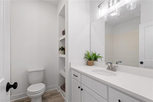 bathroom with wood-type flooring, vanity, and toilet