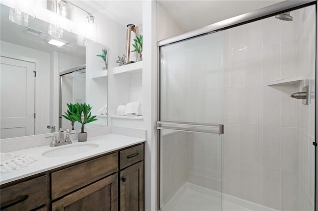 bathroom with vanity and a shower with shower door