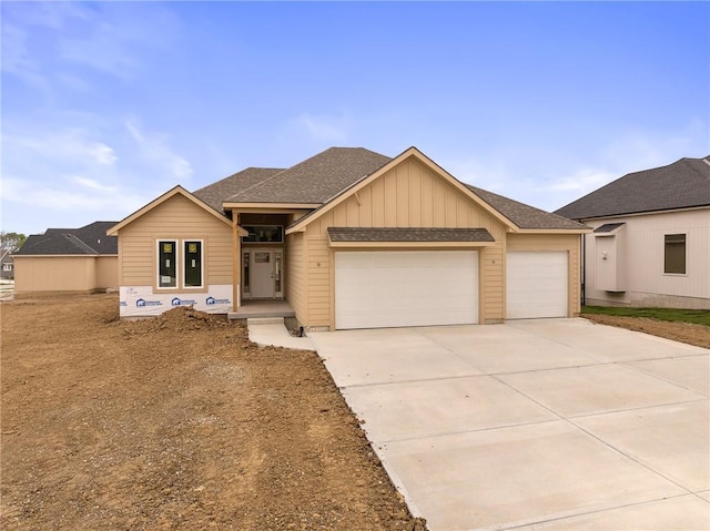 view of front of property with a garage, board and batten siding, roof with shingles, and concrete driveway