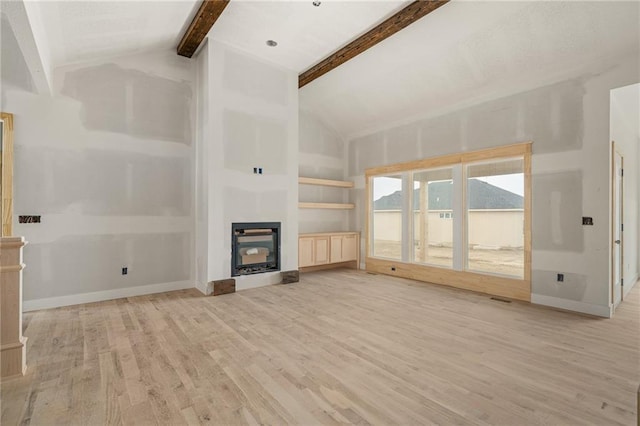 unfurnished living room featuring baseboards, a glass covered fireplace, vaulted ceiling with beams, and light wood-style flooring