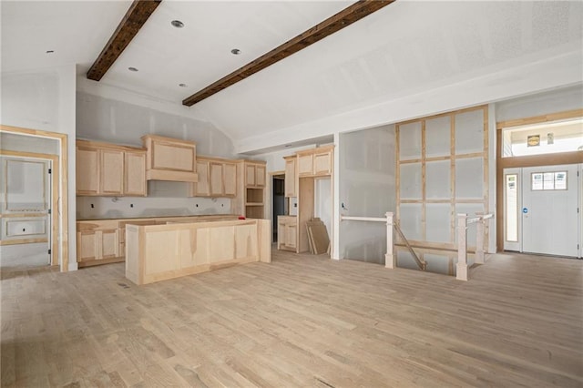 kitchen featuring a center island, lofted ceiling with beams, light wood-style flooring, and light brown cabinets