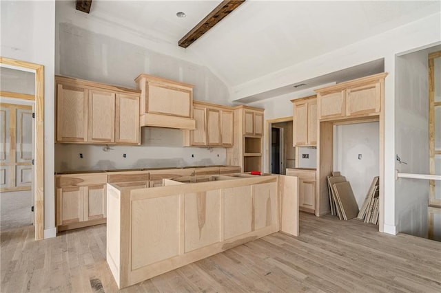 kitchen featuring light wood-style flooring, light brown cabinetry, a kitchen island, and beamed ceiling