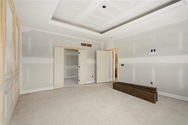empty room featuring baseboards and a raised ceiling