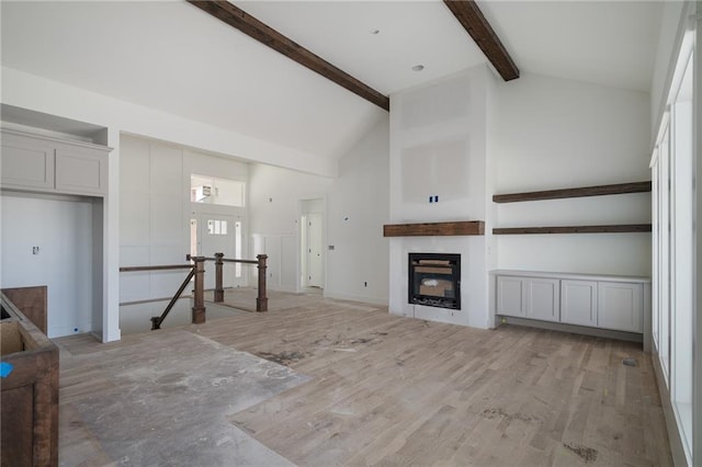 9346 Gander St, Lenexa, KS 66227 - unfurnished living room featuring beamed ceiling, high vaulted ceiling, a fireplace, plenty of natural light, and light wood-style floors