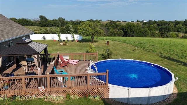 outdoor pool featuring a gazebo, a lawn, and a wooden deck