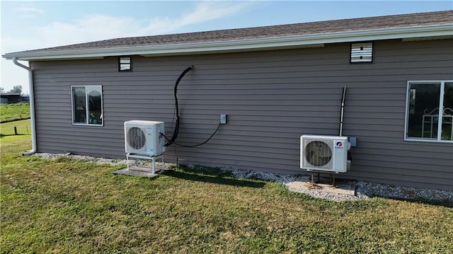 back of house featuring ac unit and a lawn