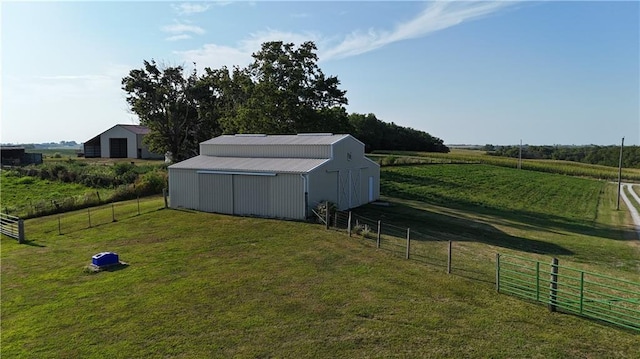 view of yard featuring an outbuilding, a pole building, a rural view, and fence