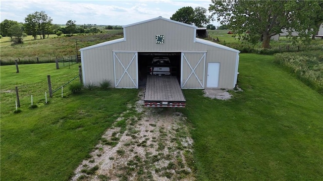 view of pole building featuring a yard, a rural view, and fence