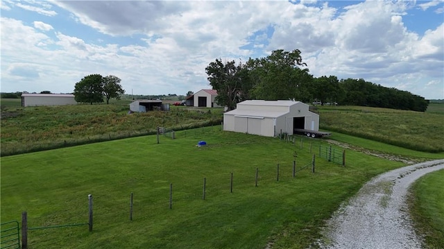 view of yard featuring an outbuilding, a pole building, a rural view, and fence