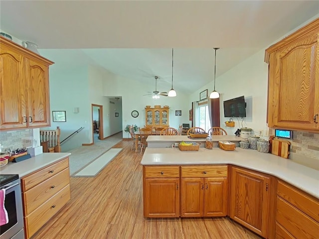 kitchen featuring a peninsula, open floor plan, light countertops, hanging light fixtures, and stainless steel electric stove