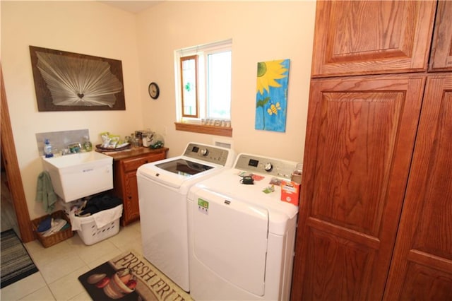 laundry room featuring a sink, cabinet space, washer and dryer, and light tile patterned flooring