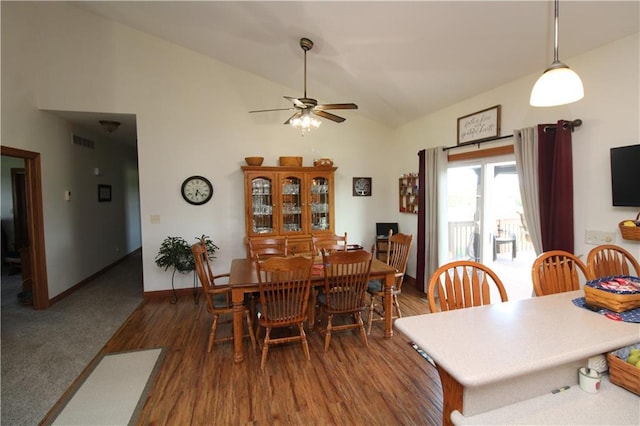 dining area with ceiling fan, high vaulted ceiling, dark wood-type flooring, visible vents, and baseboards